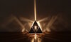 Rotated view of KAGE's Tetrahedron Platonic Solid Lamp, highlighting the high-gloss polished stainless steel and intricate fractal patterns symbolizing Fire.